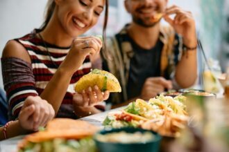 Platillos latinos saludables, tacos, tortilla dura, pareja comiendo, QuéOnnda