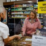 Enviar dinero con apps, Madre recibiendo dinero en efectivo en América Latina, mamá hispana, Western Union, QuéOnnda
