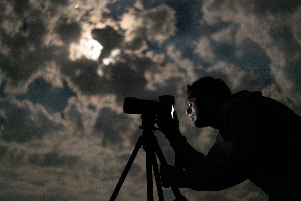 telescopio, cielo nocturno nublado, luna entre nubes, hombre observando a través de telescopio, QuéOnnda